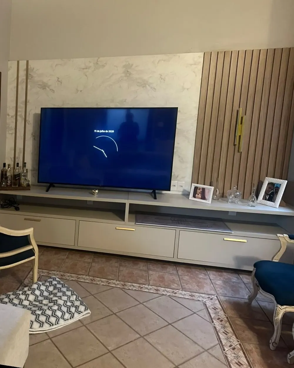Sala de TV com painel em mármore e ripado – Sobrado pós-enchente, Canoas/RS