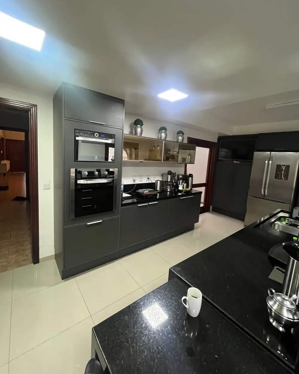 Cozinha refeita vista da bancada, com torre de fornos – Sobrado pós-enchente, Canoas/RS