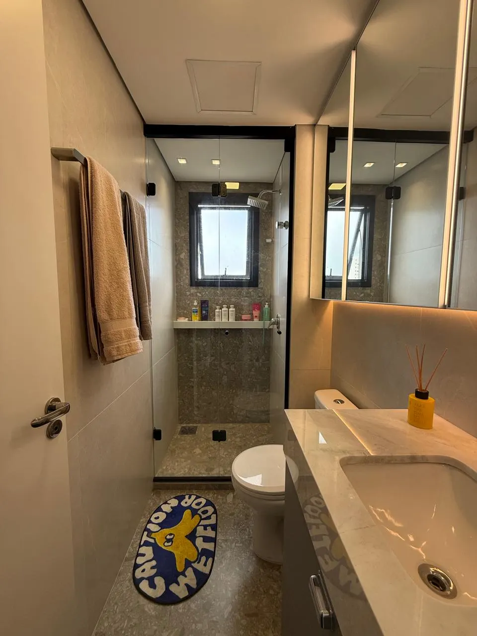 Depois – Banheiro pronto, com box de vidro, marcenaria em grafite e bancada em mármore, Apartamento N+R (Capão da Canoa/RS)