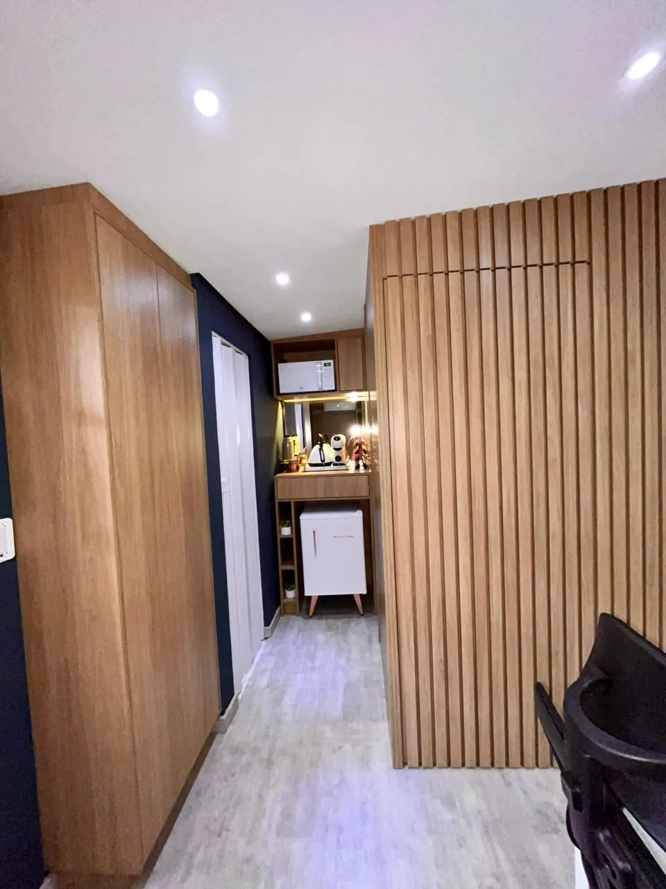 Armário do chão ao teto e mini copa com frigobar e micro-ondas embutidos na marcenaria