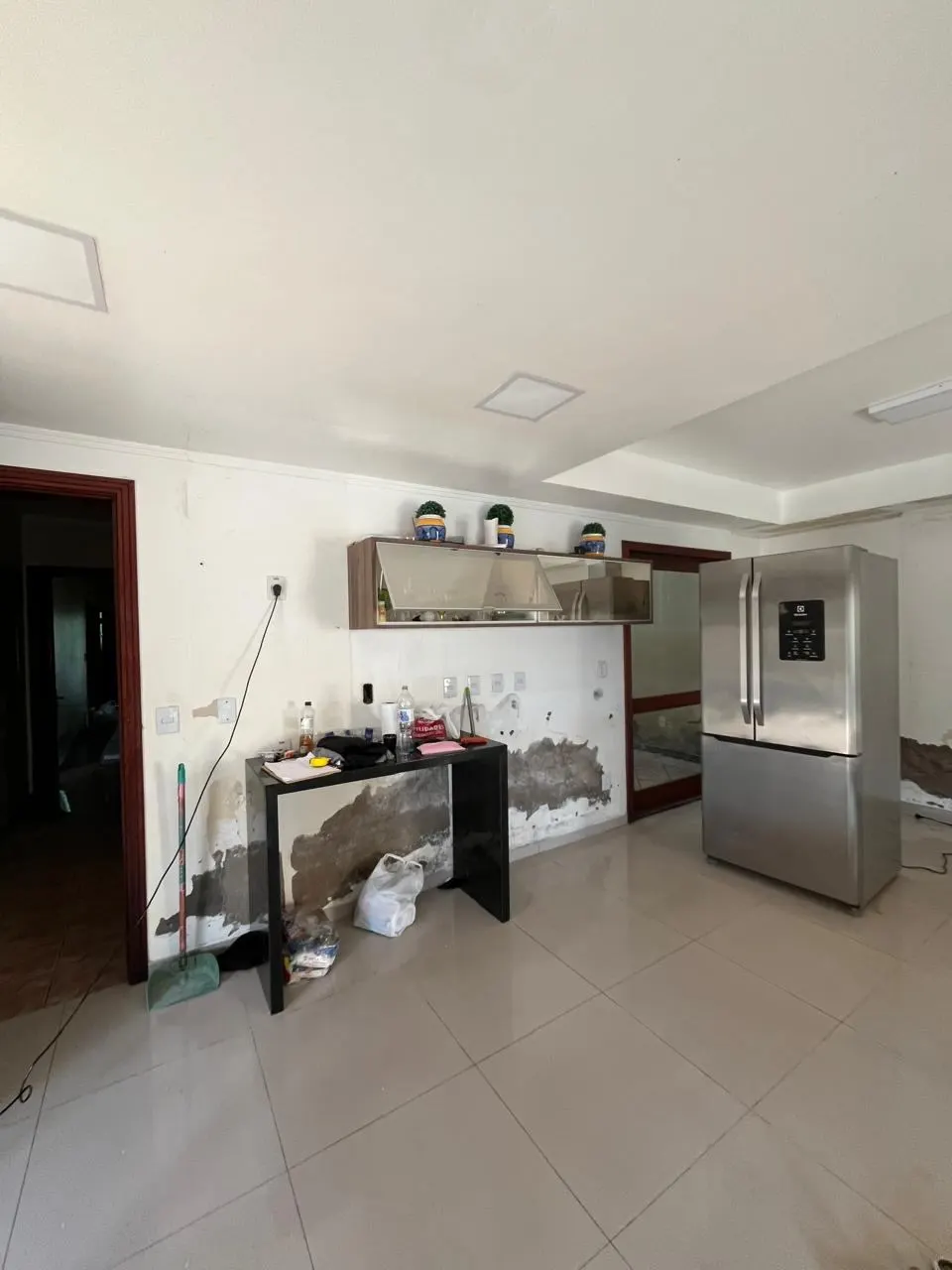 Antes – Canto da cozinha danificado pela enchente, com marcas de umidade na parede, Sobrado pós-enchente (Canoas/RS)
