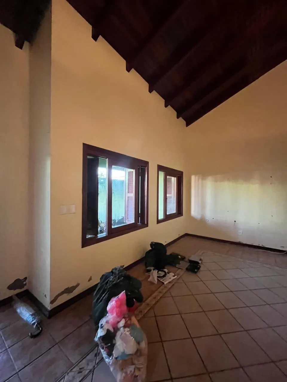 Antes – Sala antes da reforma, danificada pela enchente, com pintura descascada, Sobrado pós-enchente (Canoas/RS)