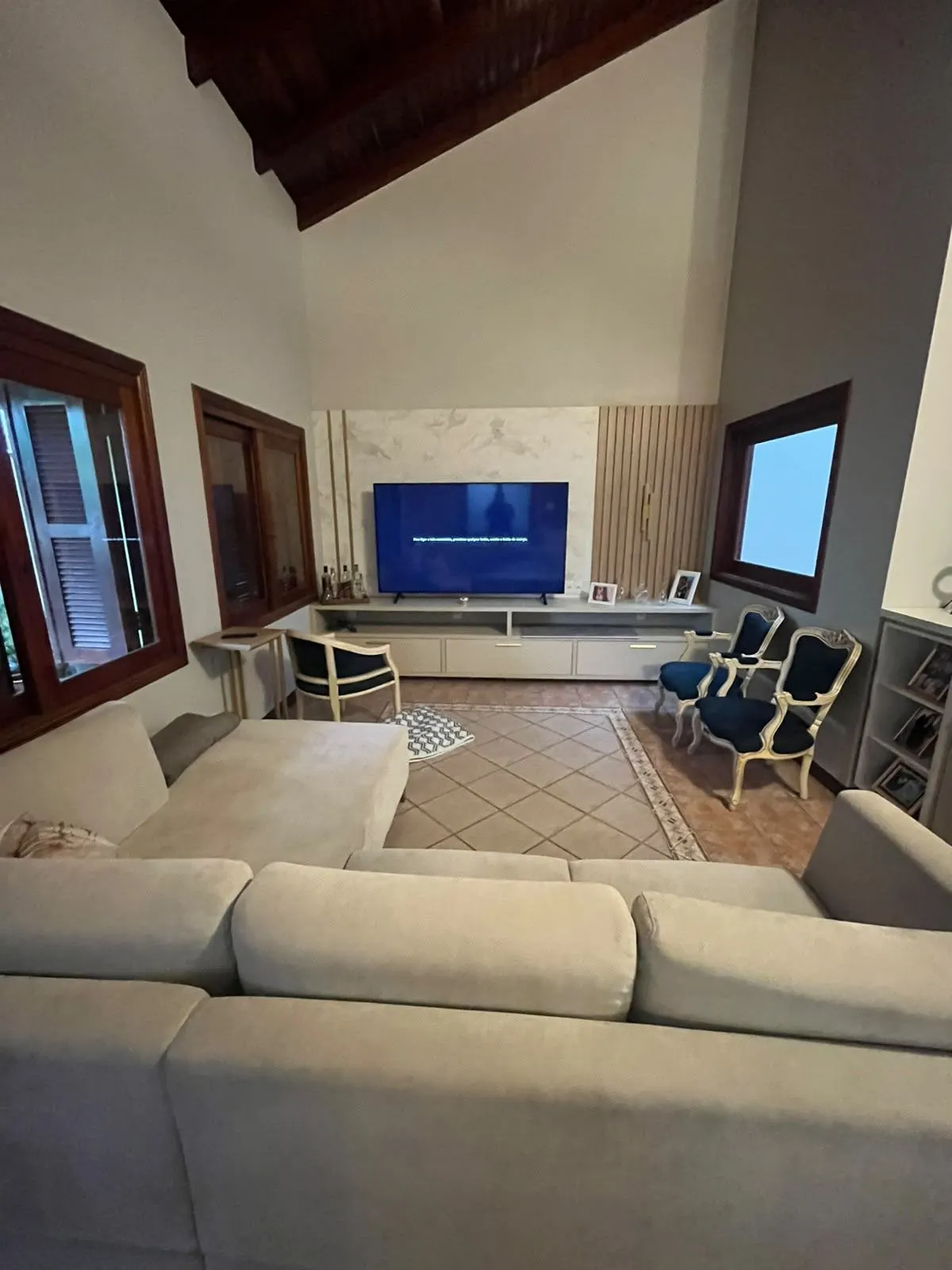 Depois – Sala reconstruída, com sofá, poltronas e painel de TV novo, Sobrado pós-enchente (Canoas/RS)